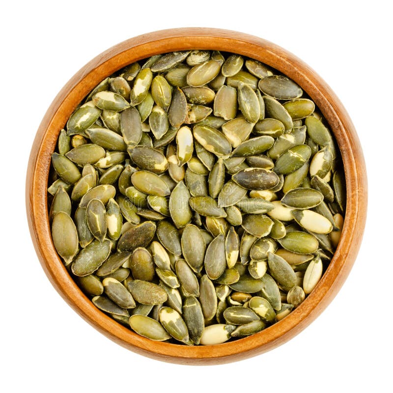 Hulled, roasted, salted pumpkin seeds, in a wooden bowl