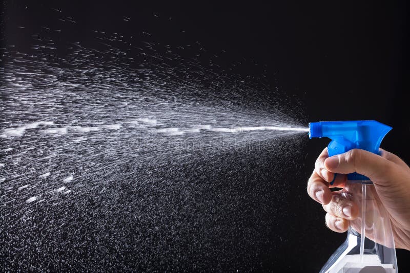 Human Hand Spraying Water With Spray Bottle