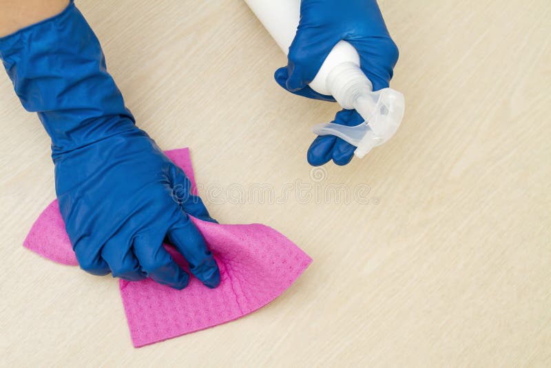 A Human Hands in a Protective Gloves Disinfect the Table Using