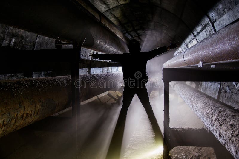 Human silhouette with in underground communication, heating main, sewer tunnel, etc. royalty free stock photo