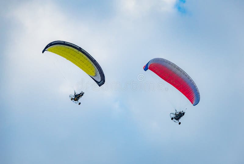 Humeur d'été : deux pilotes le parapentiste sur le fond de ciel bleu photos libres de droits Humeur d'été : deux pilotes le parapentiste sur le fond de ciel bleu photos libres de droits