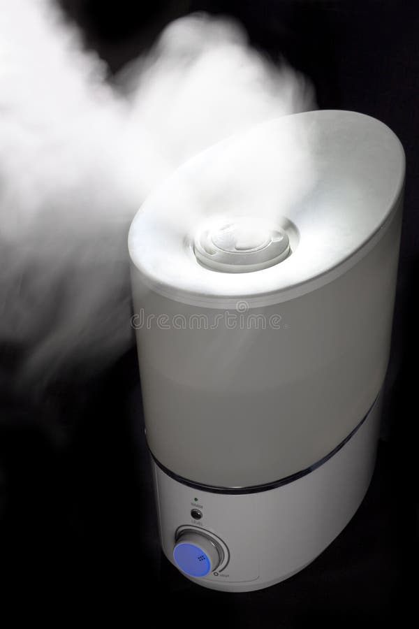 Humidifier spreading steam in darkness royalty free stock photography