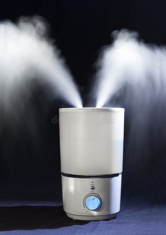 Humidifier spreading steam in darkness stock photos