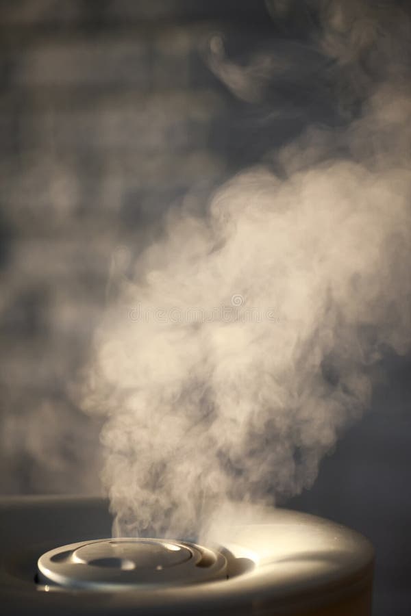 Humidifier spreading steam with white brick background royalty free stock image