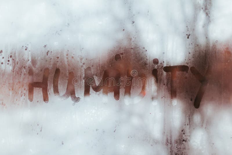 Humidity word written on wet window. High level of dampness in apartment