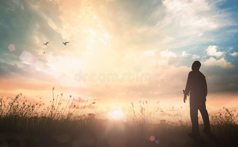 Humilde homem parado sobre a luz do sol com o pôr do sol do verão