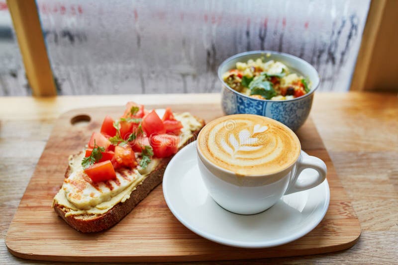 Hummus и сандвич томата, салат и свежий горячий кофе капучино