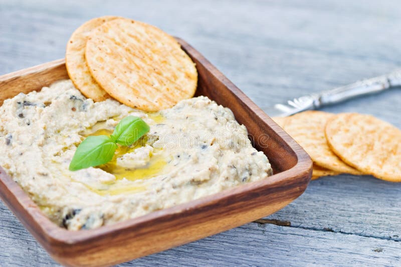 Hummus dip with olive oil and basil leaves. Shallow DOF with focus on leaves.