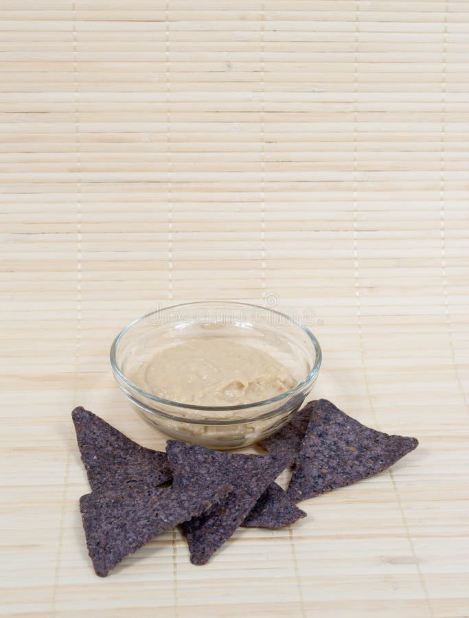 Hummus con i chip di tortiglia blu del cereale immagini stock libere da diritti Hummus con i chip di tortiglia blu del cereale immagini stock libere da diritti