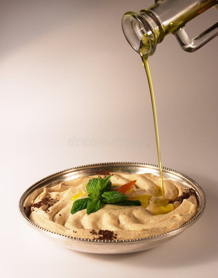 Hummus e petróleo verde-oliva foto de stock royalty free Hummus e petróleo verde-oliva foto de stock royalty free