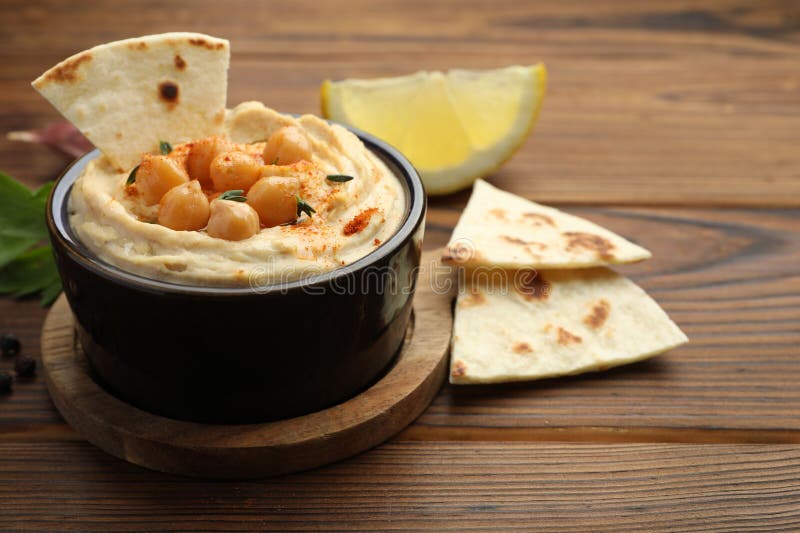 Hummus mit Kichererbsen und Pitas auf Holztisch serviert stockbild
