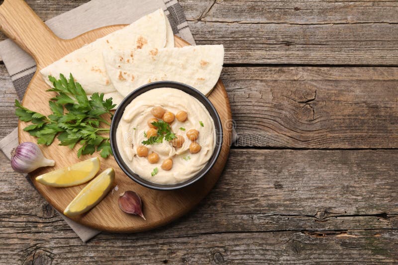 Hummus mit Kichererbsen und Pitas, serviert auf Holztisch flach. Platz für Text lizenzfreies stockbild