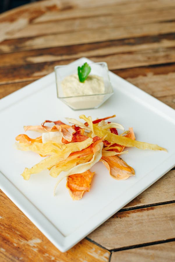 Hummus with Root Vegetable Color Chips in Restaurant Stock Photo
