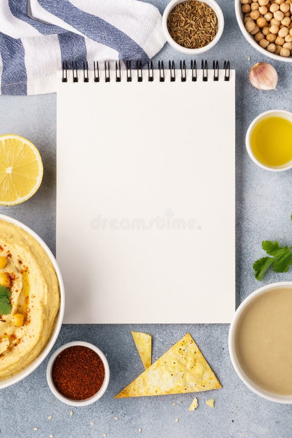 Hummus, öppen receptbok och ingredienser för att laga mat arkivbilder Hummus, öppen receptbok och ingredienser för att laga mat arkivbilder