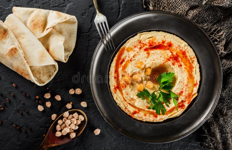 Hummus нутов с оливковым маслом, паприкой в плите над темной каменной предпосылкой Здоровая еда vegan, очищает еду, dieting, стоковое фото Hummus нутов с оливковым маслом, паприкой в плите над темной каменной предпосылкой Здоровая еда vegan, очищает еду, dieting, стоковое фото