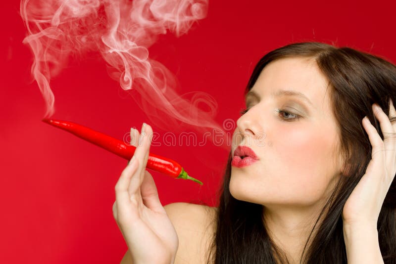 Humo de la mujer joven del retrato de la pimienta de chile candente imágenes de archivo libres de regalías Humo de la mujer joven del retrato de la pimienta de chile candente imágenes de archivo libres de regalías