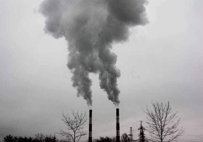 Humo industrial de una chimenea en un cielo nublado fotos de archivo Humo industrial de una chimenea en un cielo nublado fotos de archivo