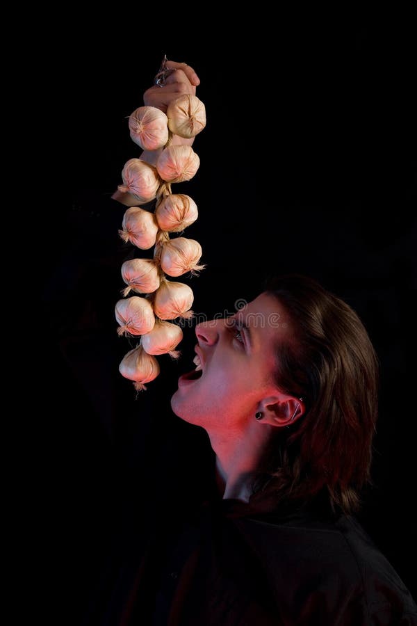 Humorous shot of vampire eating garlic stock image