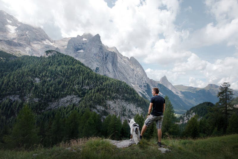 Hund mit einem Mann in den Bergen bei Sonnenaufgang Reise mit einem Haustier lizenzfreie stockfotos Hund mit einem Mann in den Bergen bei Sonnenaufgang Reise mit einem Haustier lizenzfreie stockfotos