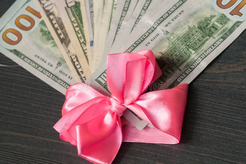 Hundra dollarräkningar som slås in i ett rosa band royaltyfria bilder Hundra dollarräkningar som slås in i ett rosa band royaltyfria bilder