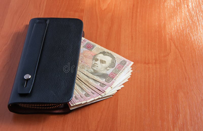 Hundred Ukrainian hryvnia banknotes in black purse