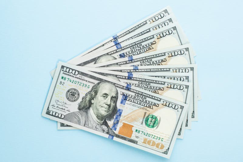 Hundred US dollar money cash on blue background. American Dollars 100 note profit concept