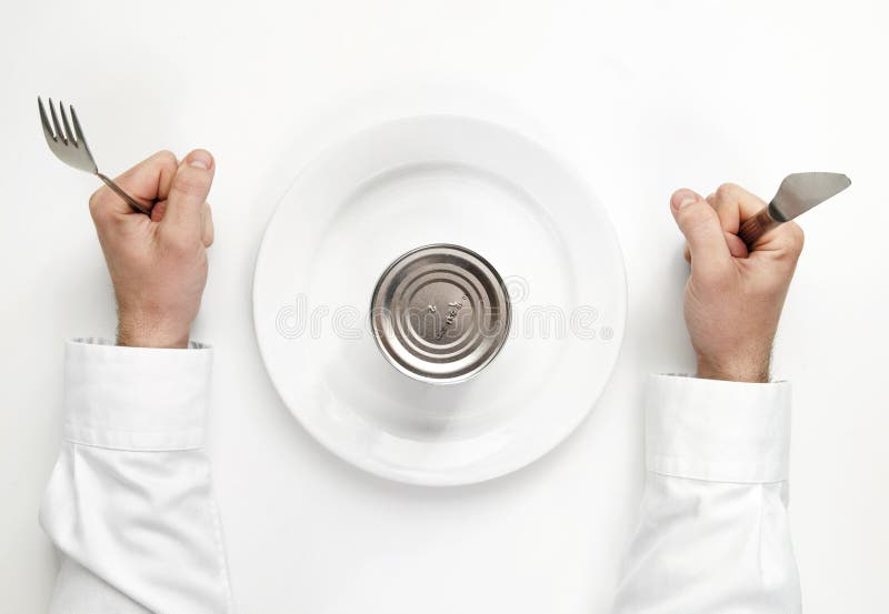 Hunger concept. unopened tin box with human hands holding fork a