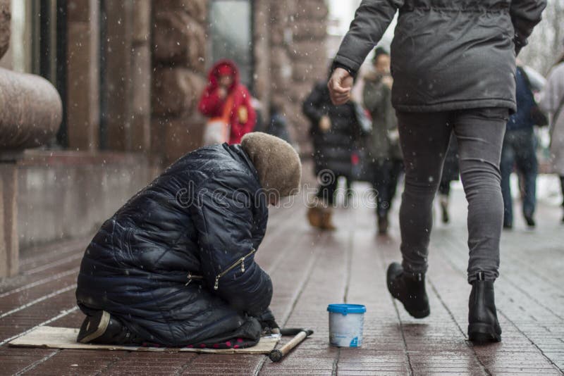 Hungrige obdachlose Bettlerfrau bitten um Geld auf der städtischen Straße in der Stadt von den Leuten, die vorbei, dokumentarisch