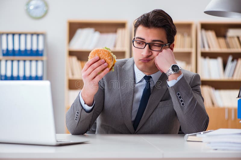 The hungry funny businessman eating junk food sandwich royalty free stock photo The hungry funny businessman eating junk food sandwich royalty free stock photo