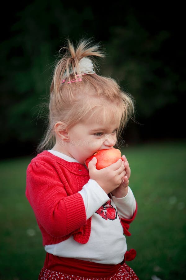 Hungry girl eating apple