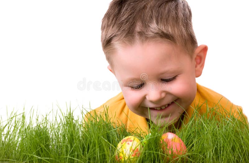 Easter egg hunt. Cute boy searching for easter eggs hidden in fresh green grass. Isolated on white background. Easter egg hunt. Cute boy searching for easter eggs hidden in fresh green grass. Isolated on white background