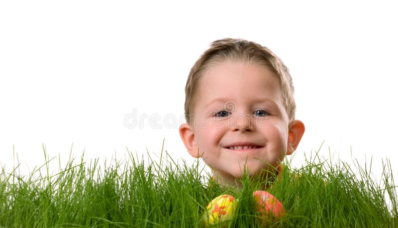 Easter egg hunt. Cute boy searching for easter eggs hidden in fresh green grass. Isolated on white background. Easter egg hunt. Cute boy searching for easter eggs hidden in fresh green grass. Isolated on white background
