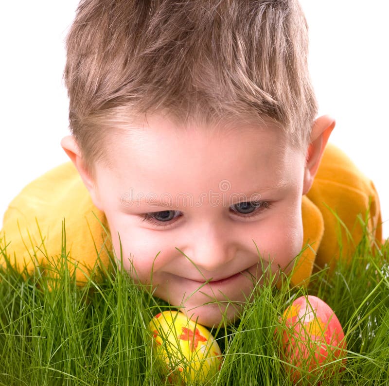 Easter egg hunt. Cute boy searching for easter eggs hidden in fresh green grass. Isolated on white background. Easter egg hunt. Cute boy searching for easter eggs hidden in fresh green grass. Isolated on white background