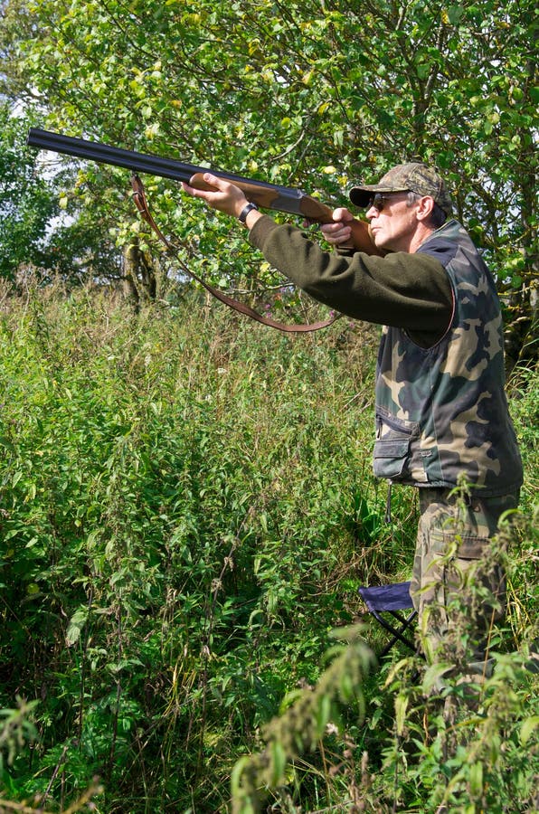 Hunter aiming pigeons stock images