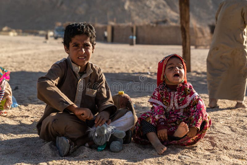 Hurghada / Egitto - 21 luglio 2019: Bambini arabi giocano nel villaggio di Beduin nel deserto egiziano immagine stock libera da diritti Hurghada / Egitto - 21 luglio 2019: Bambini arabi giocano nel villaggio di Beduin nel deserto egiziano immagine stock libera da diritti