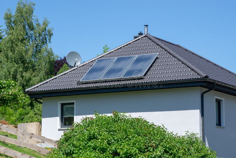 Hus med det belade med tegel taket och den sol- termiska kraftverket royaltyfri fotografi Hus med det belade med tegel taket och den sol- termiska kraftverket royaltyfri fotografi
