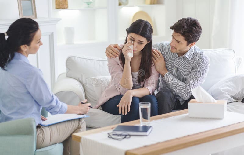 Husband Comforting His Crying Wife during Family Therapy Stoc image