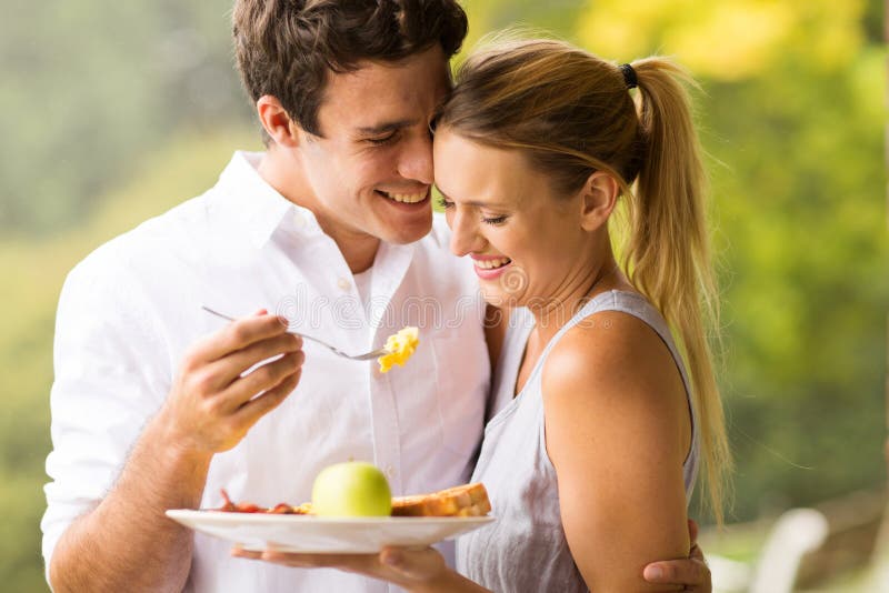 Husband feeding wife breakfast