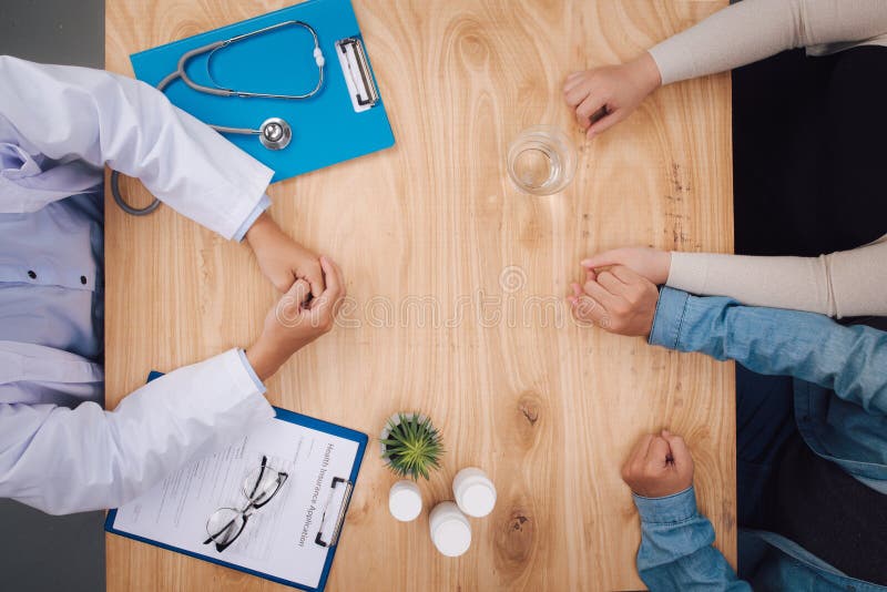 Husband Holding Wife`s Hand at Doctor`s Off