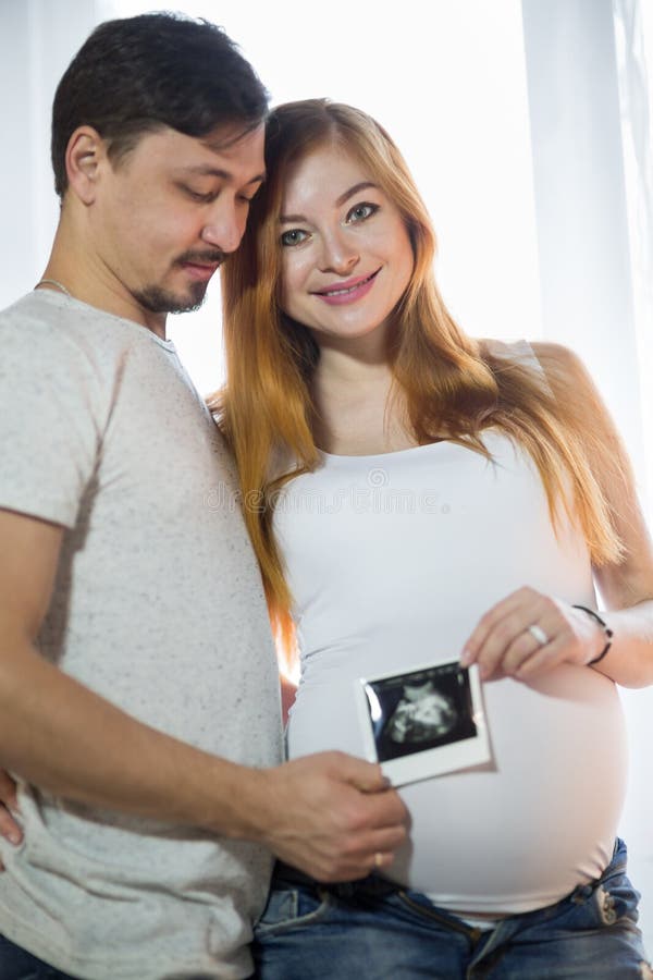Husband and Pregnant Wife in a Room Stock Image