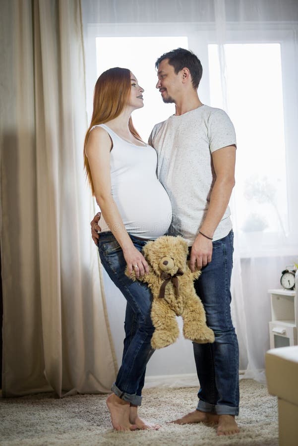 Husband and Pregnant Wife in a Room Stock Photo