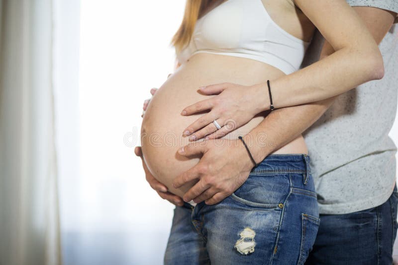 Husband and Pregnant Wife in a Room Stock Photo