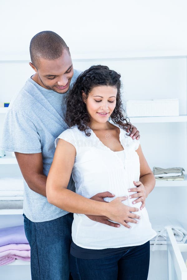 Man Touching Pregnant Womans Stomach while Relaxing on Bed Stock Im