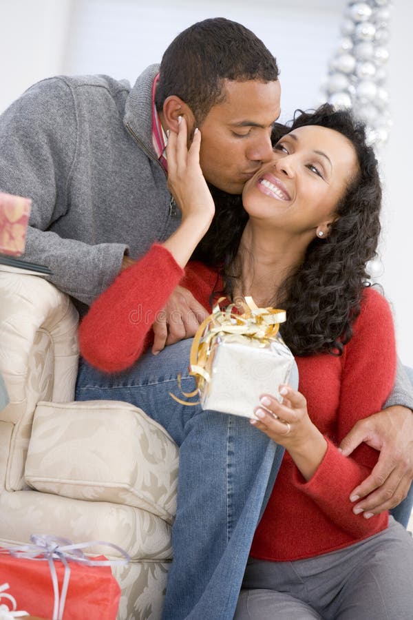 Husband And Wife Exchanging Christmas Gifts