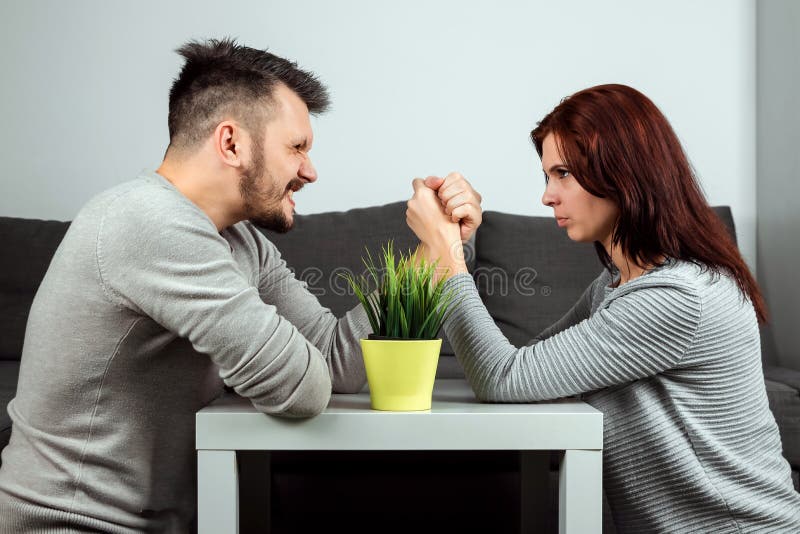 Husband and wife are fighting in their arms, arm wrestling between male and female. Family quarrel, showdown, division of property