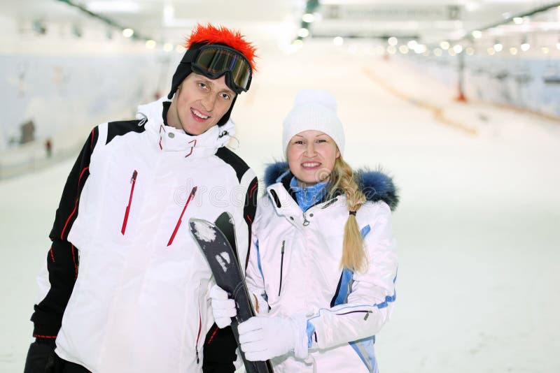 Husband and wife stand with skis