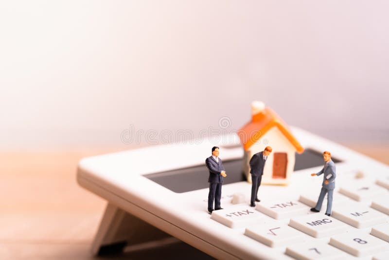 Husmodell och businessmans på räknemaskinen med ordskatten royaltyfri fotografi Husmodell och businessmans på räknemaskinen med ordskatten royaltyfri fotografi