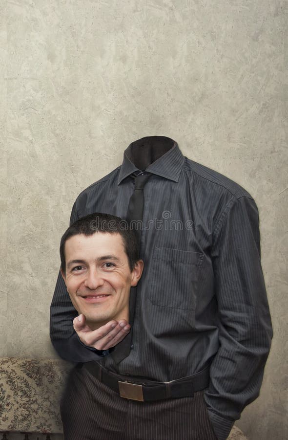 Headless body of a businessman with his smiling head in his hand, textured background with copy space. Headless body of a businessman with his smiling head in his hand, textured background with copy space.