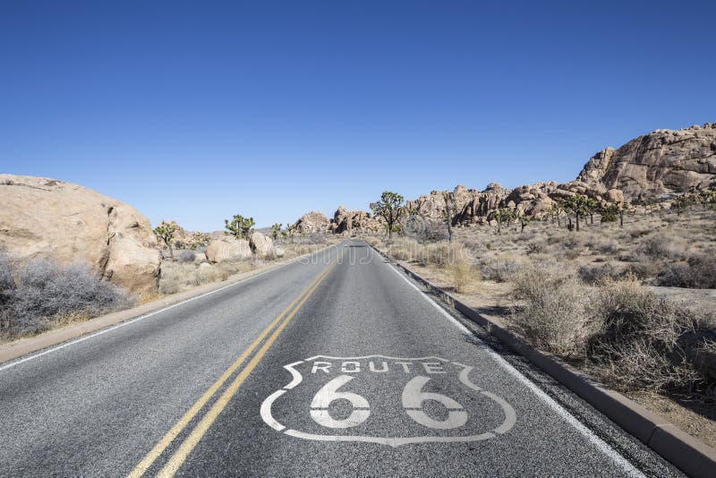 Joshua tree highway with Route 66 pavement sign in California's Mojave desert. Joshua tree highway with Route 66 pavement sign in California's Mojave desert.