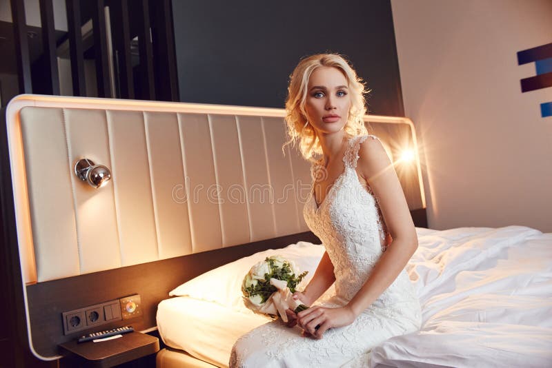 Huwelijksboeket in mand Een vrouw in een witte huwelijkskleding die een boeket van bloemen in haar handen houden Mooi blondemeisj stock afbeeldingen Huwelijksboeket in mand Een vrouw in een witte huwelijkskleding die een boeket van bloemen in haar handen houden Mooi blondemeisj stock afbeeldingen